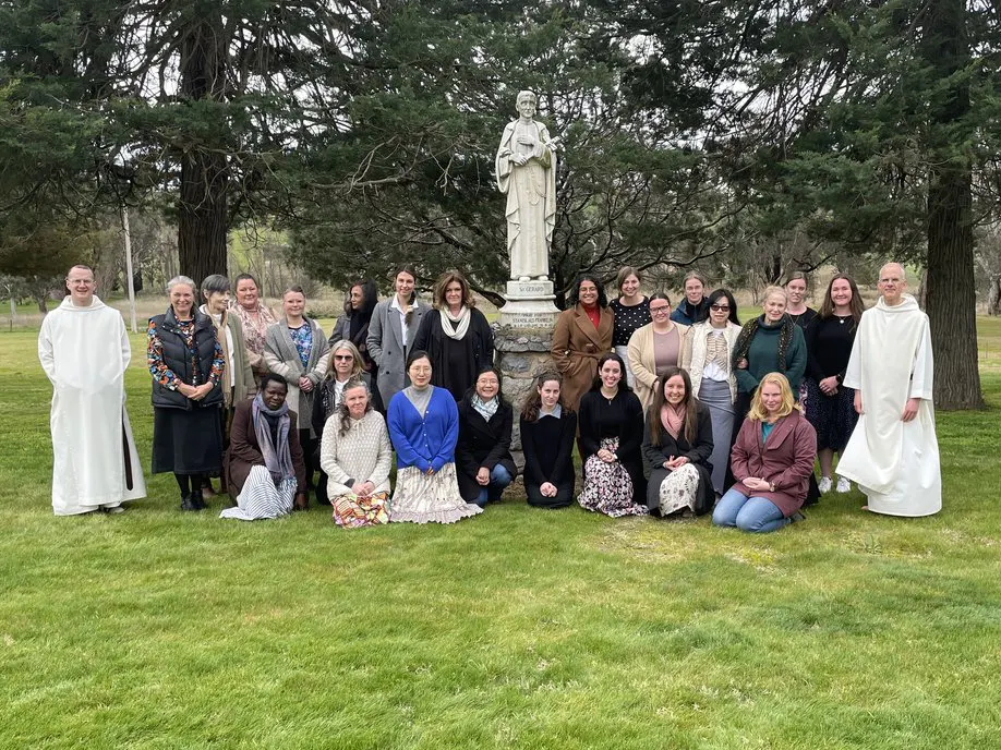 Group photo of retreatants in front of statue of St Clement Marie Hofbauer.