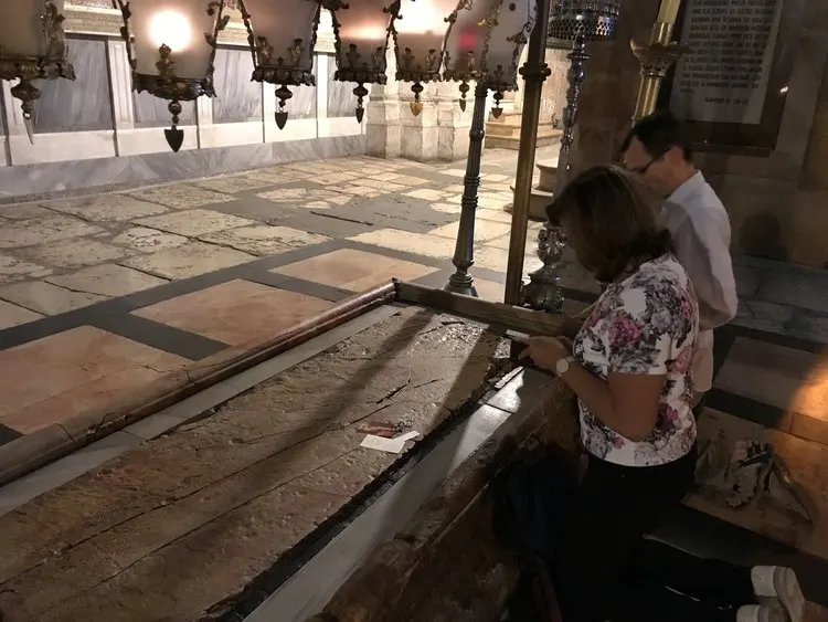 Pilgrims praying before the slab of anointing, where the Body of the Lord was anointed before burial.